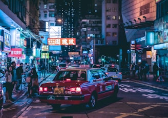 red Taxicab on street during night ime