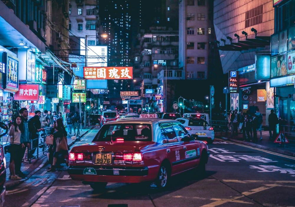 red Taxicab on street during night ime