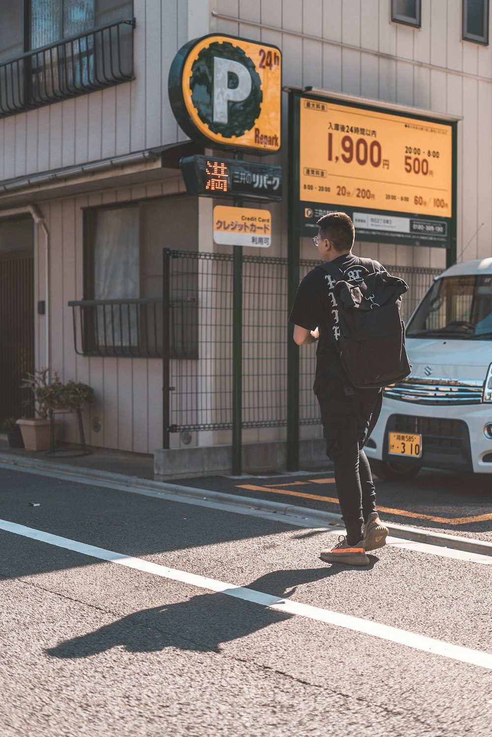 Homme en tee-shirt noir traversant la route