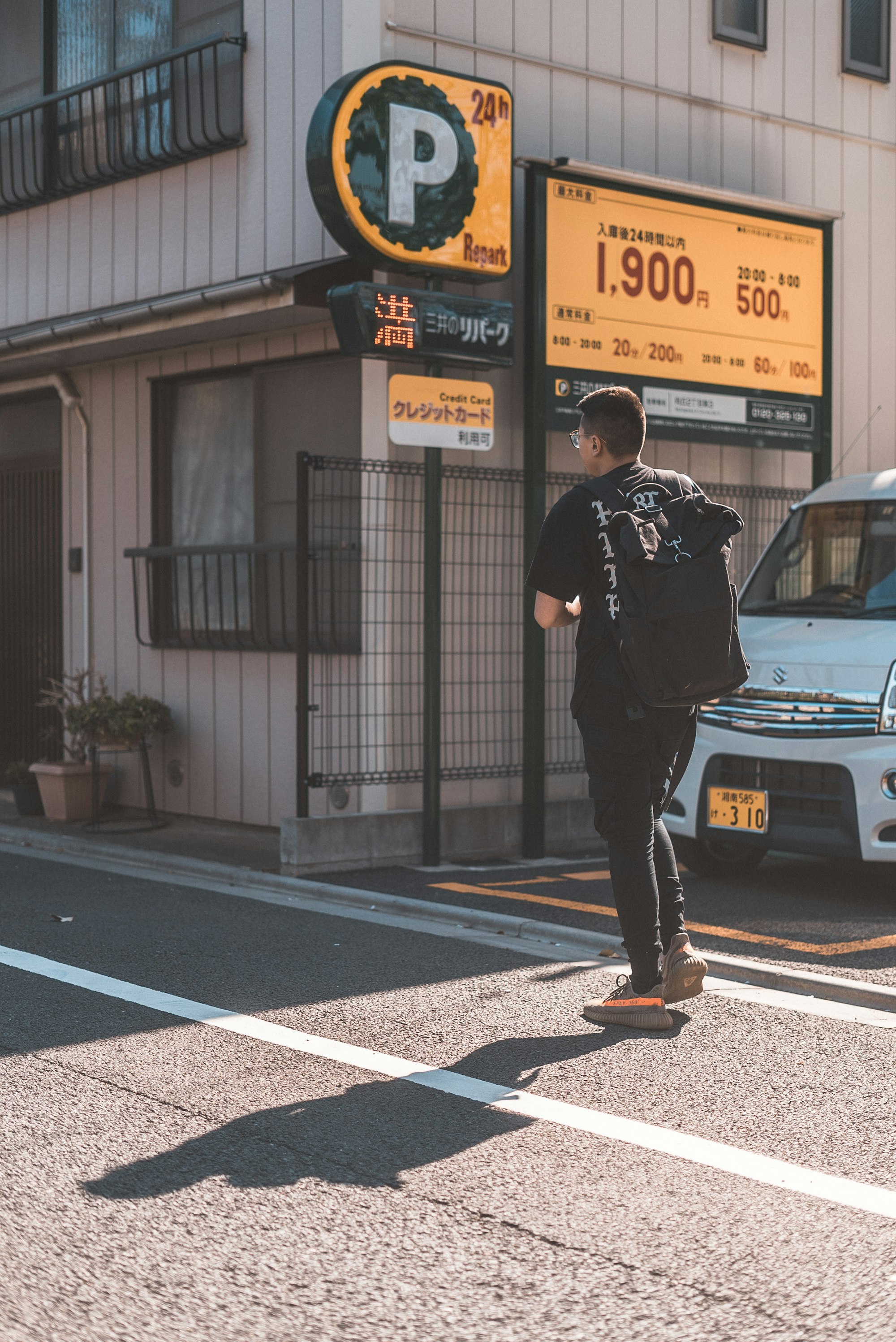 man in black tee shirt crossing road