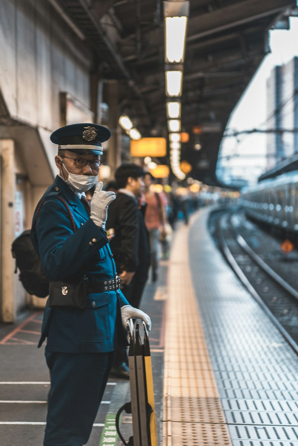 man in a uniform by train tracks
