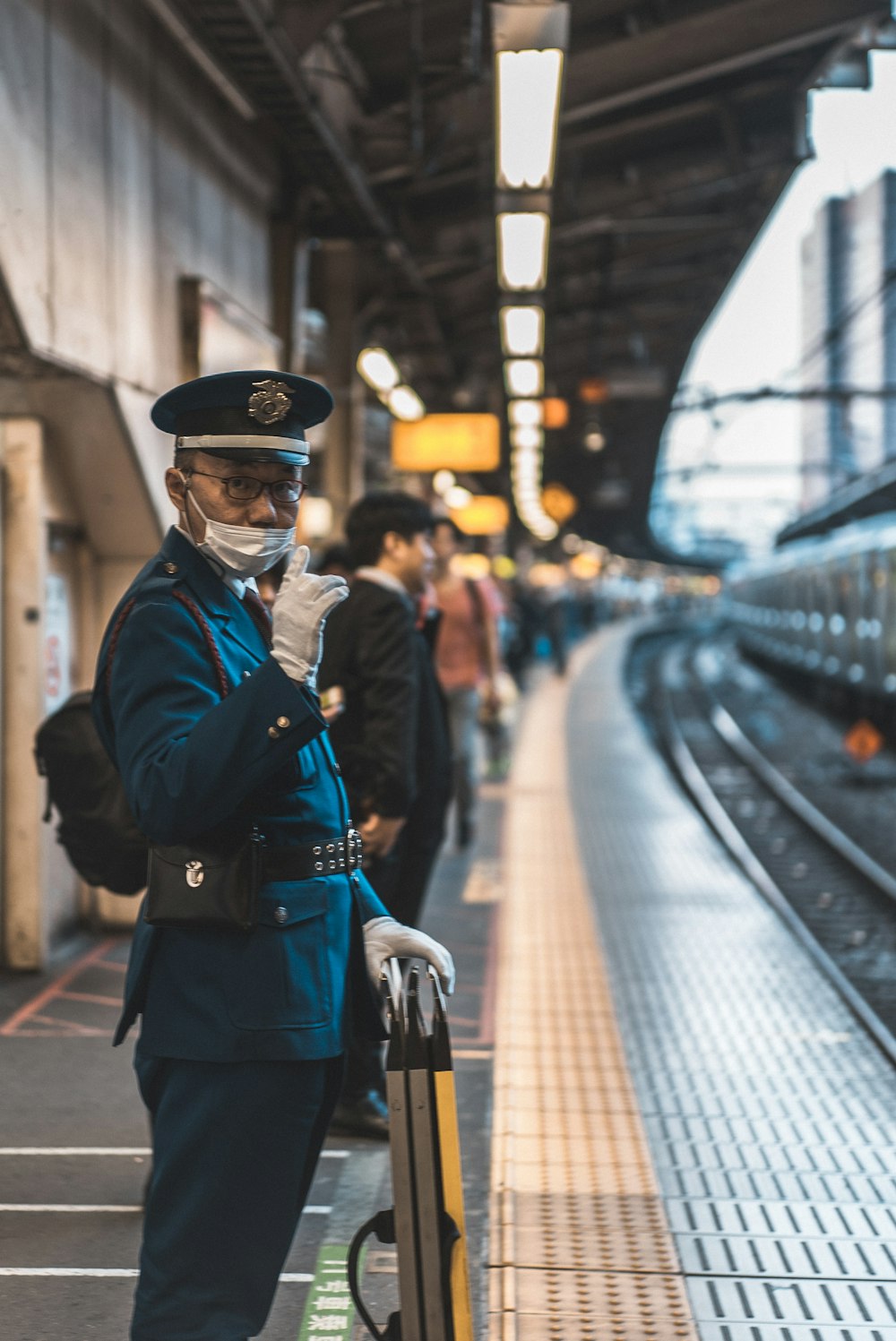 homem de uniforme por trilhos de trem