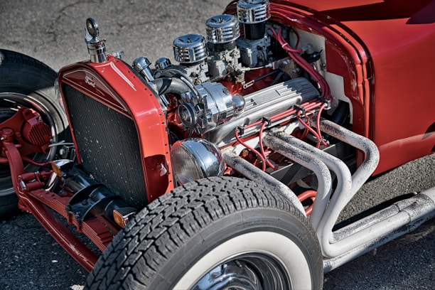 A close-up of classic car parts displayed on a wooden table.