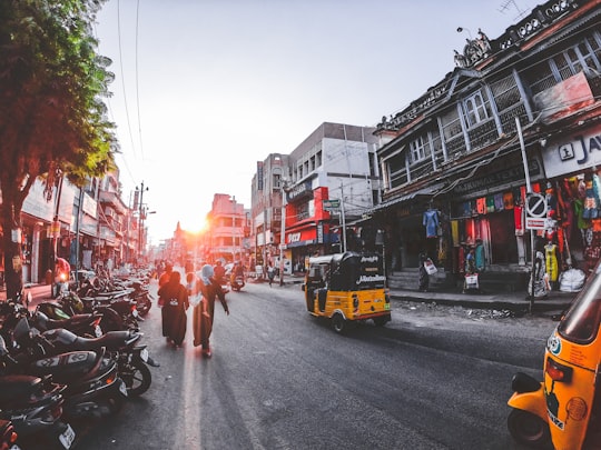 people and vehicles on street in Madurai India