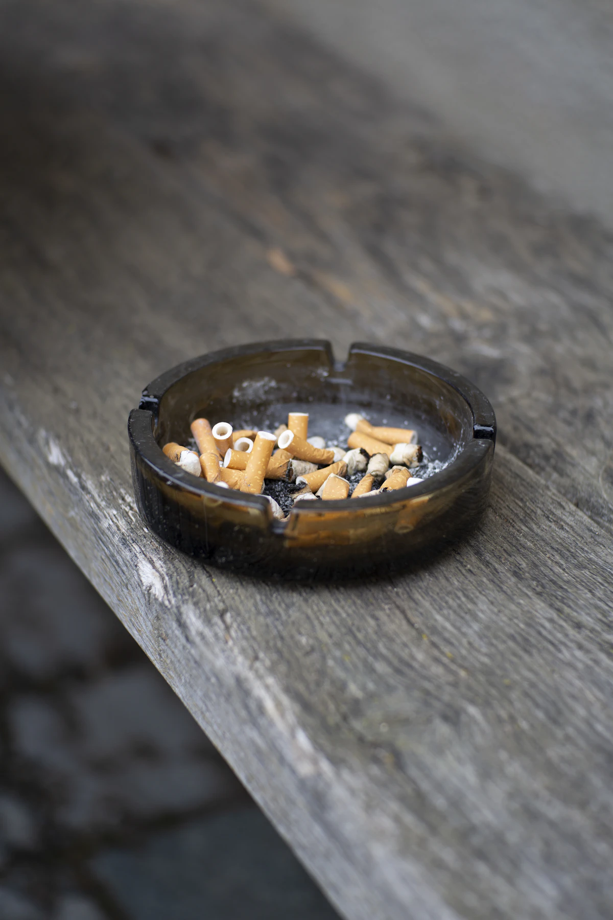 Cigar with light wrapper resting in a brass ashtray.