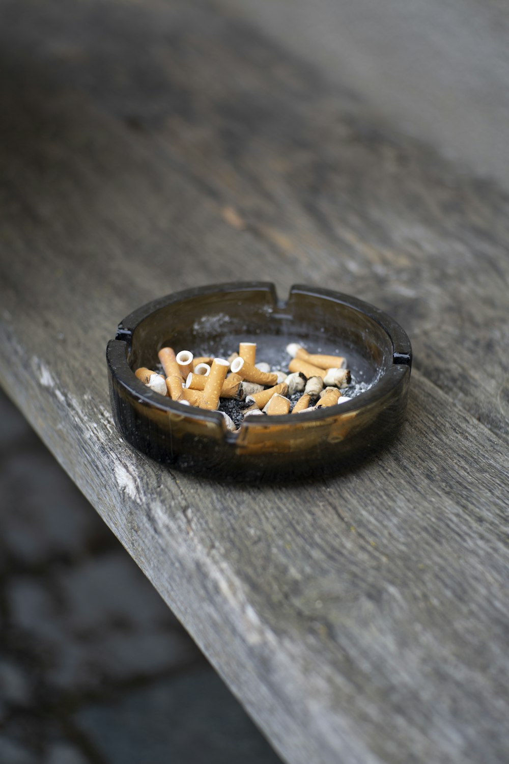 round gray ashtray on brown wooden table top