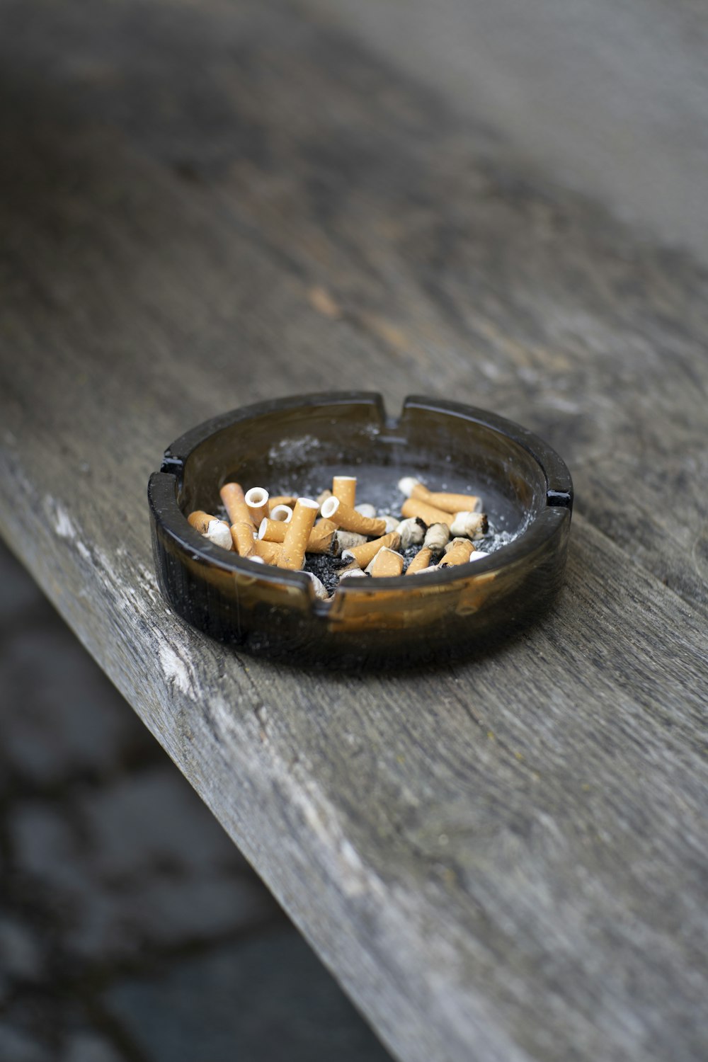 Cendrier rond gris sur plateau de table en bois brun