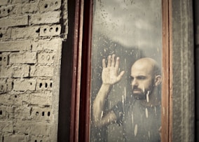 man leaning on window