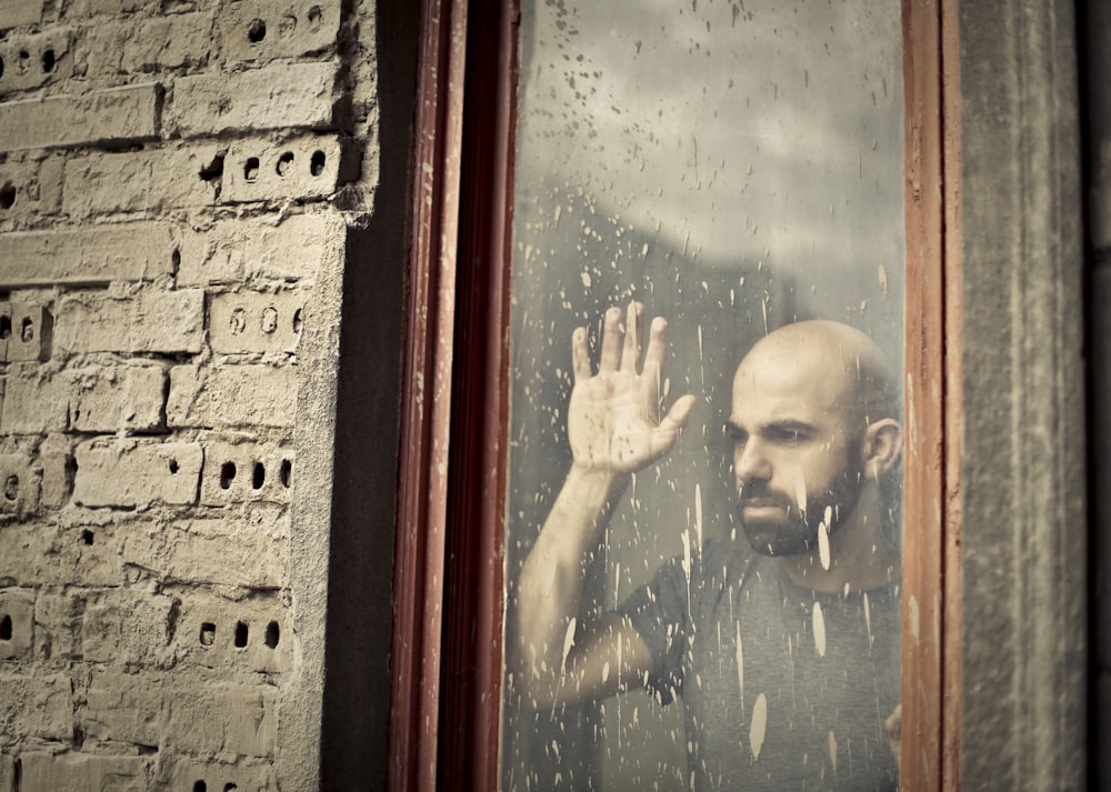 man leaning on window