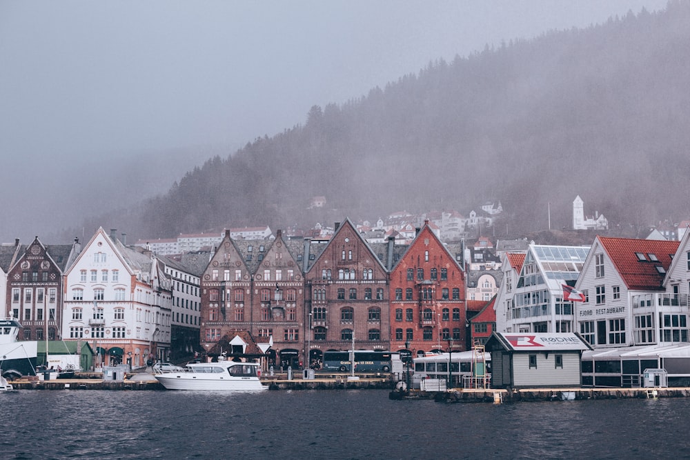 white boat on body of water near buildings