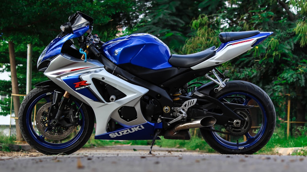 moto deportiva Suzuki azul y blanca aparcada durante el día