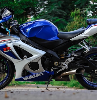 blue and white Suzuki sports bike parked during daytime