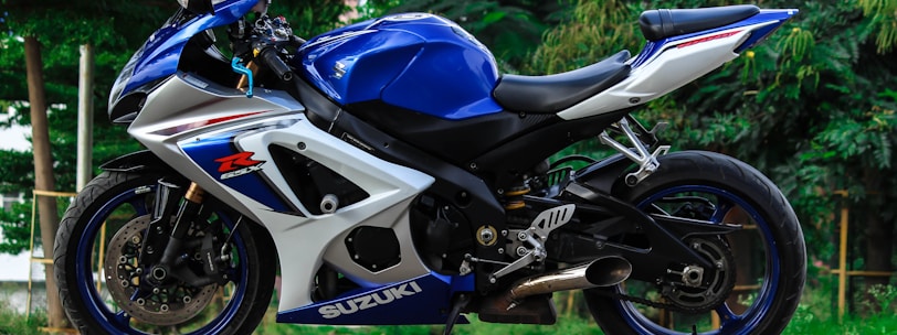 blue and white Suzuki sports bike parked during daytime