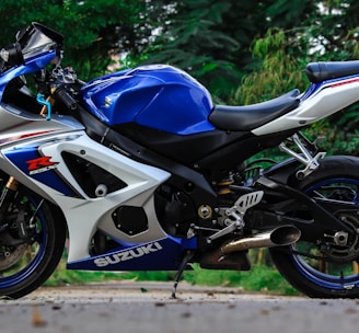 blue and white Suzuki sports bike parked during daytime