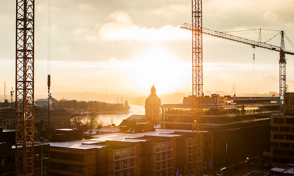 tower crane near building under cloudy sky at daytime