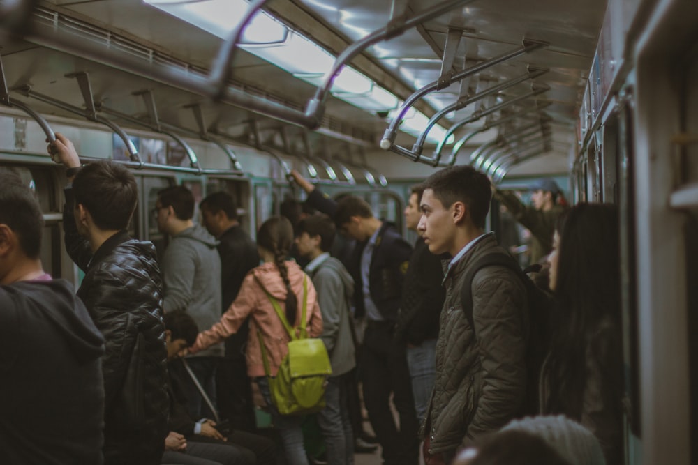 man standing in train during night time