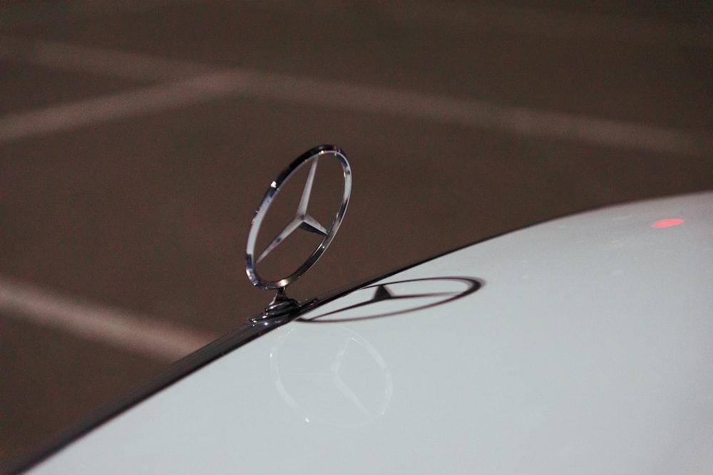 selective focus photography of Mercedes-Benz emblem