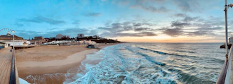 Vue panoramique d'une plage au coucher du soleil avec des couleurs chaudes.