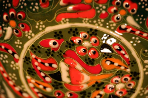 Artistic ceramic piece with intricate pre-Columbian patterns in deep red and black.