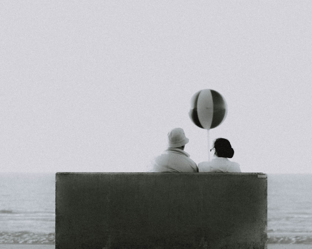 couple sitting on bench in front of beach