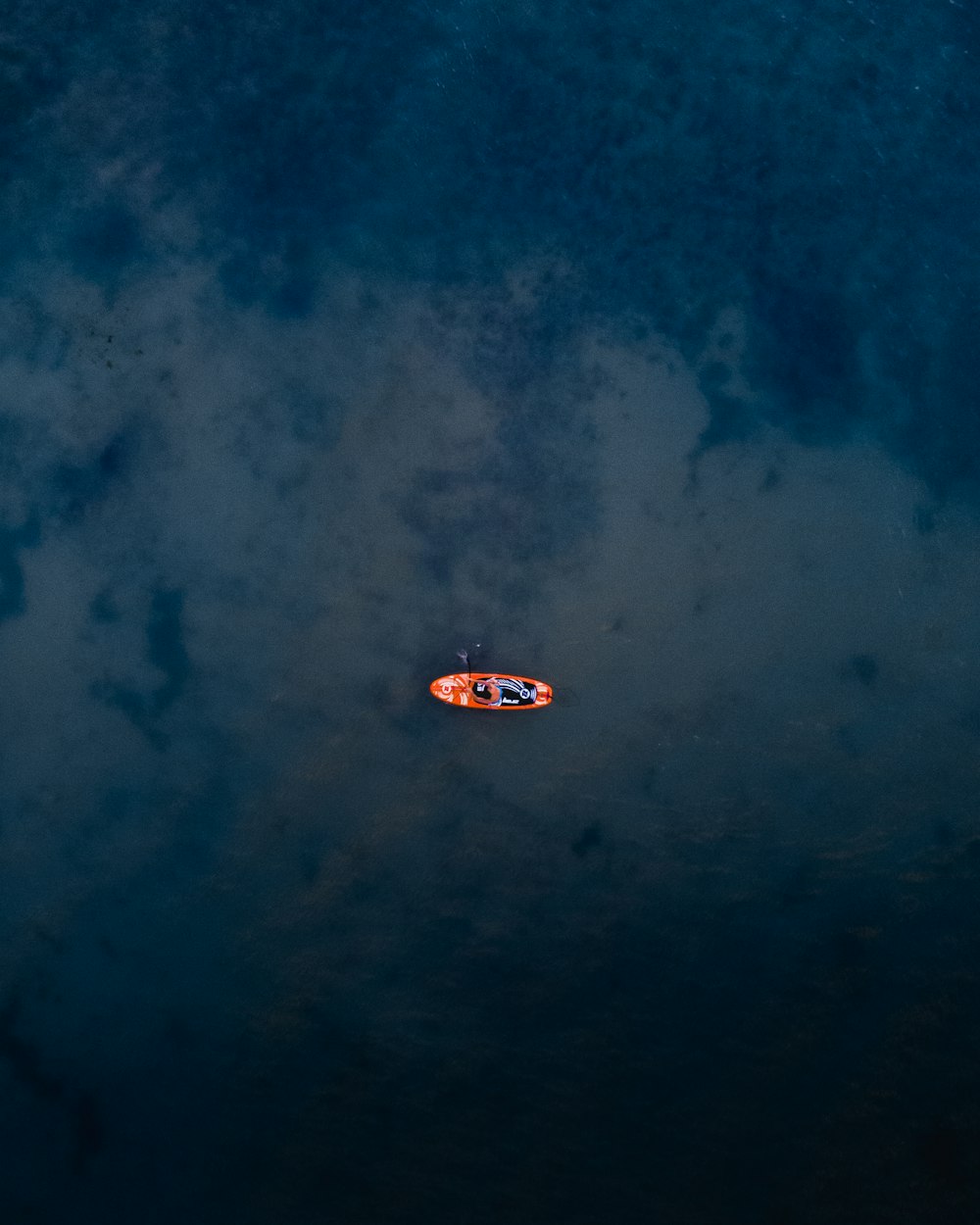 person riding orange canoeboat