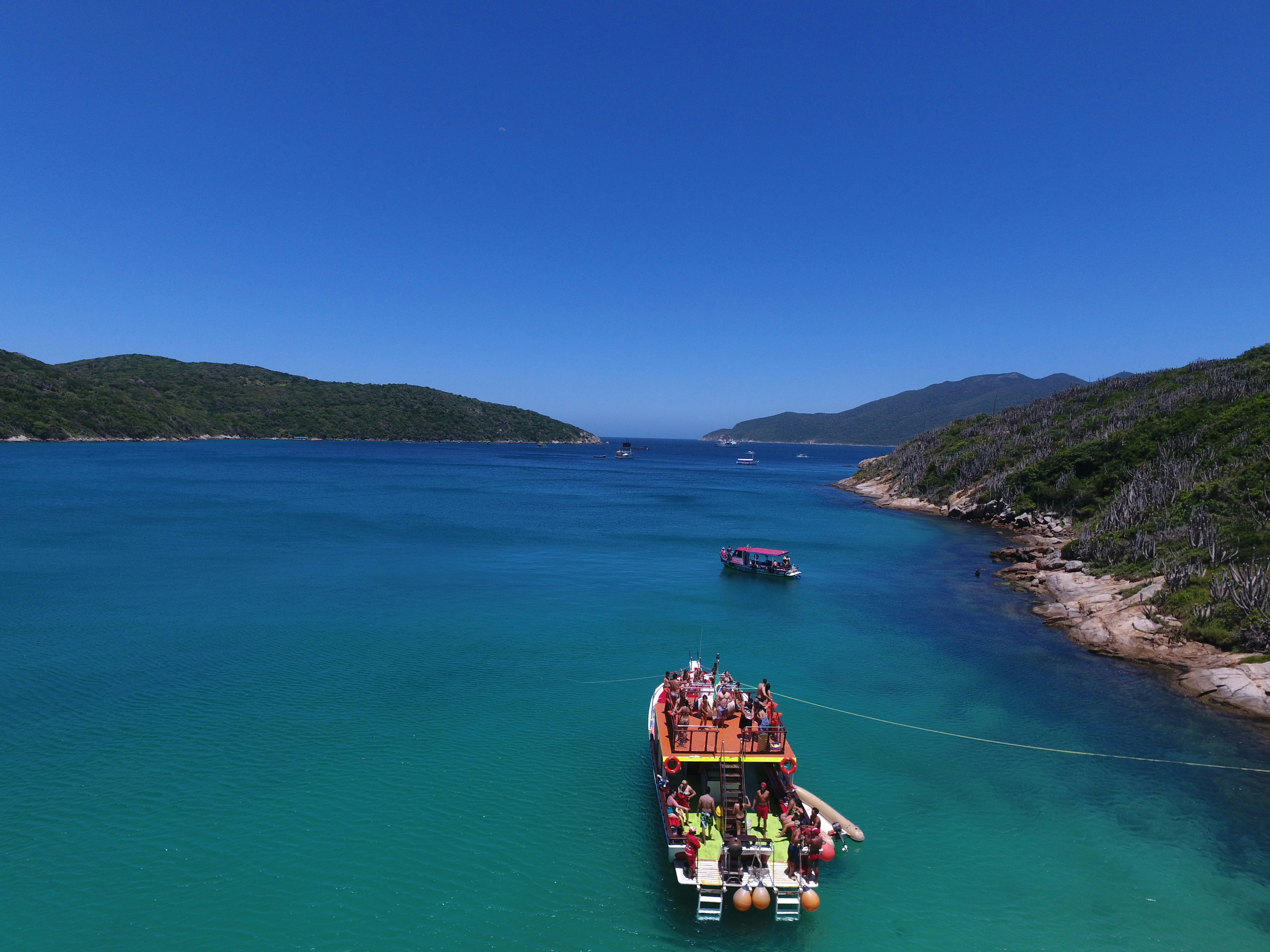 Happy tourists on boat deck enjoying island hopping tour on sunny day