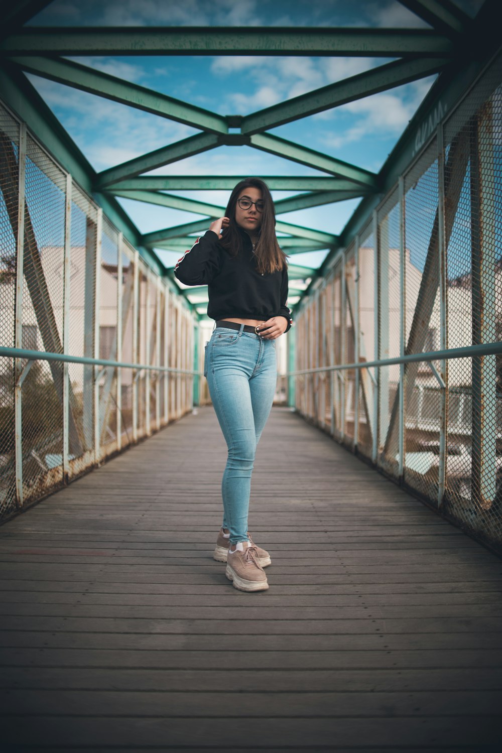 woman wearing black dress standing on the bridge