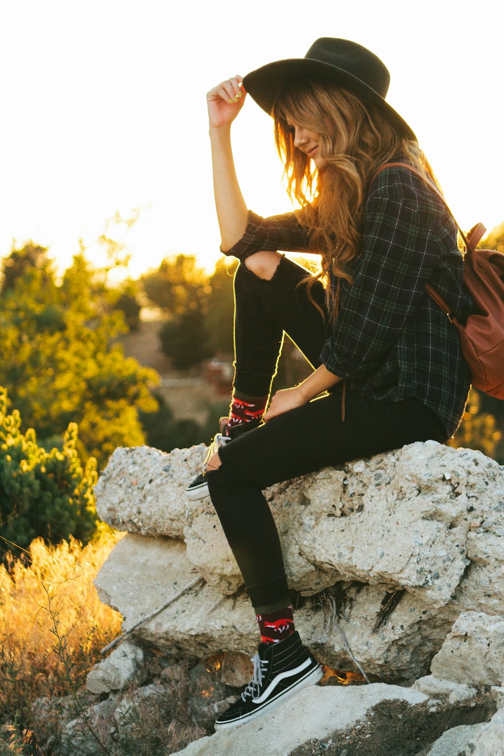 woman sitting on rock