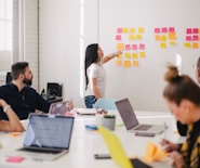 woman placing sticky notes on wall