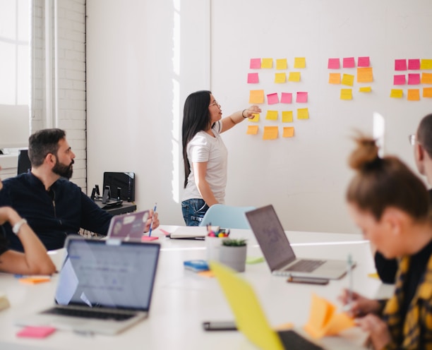 woman placing sticky notes on wall