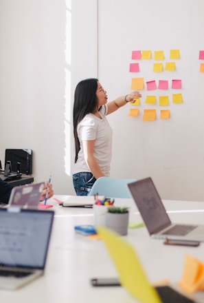 woman placing sticky notes on wall
