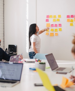 woman placing sticky notes on wall