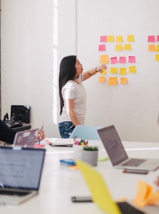 woman placing sticky notes on wall