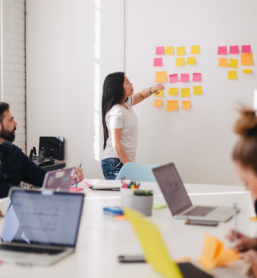 woman placing sticky notes on wall