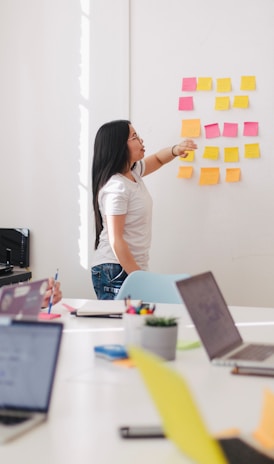 woman placing sticky notes on wall