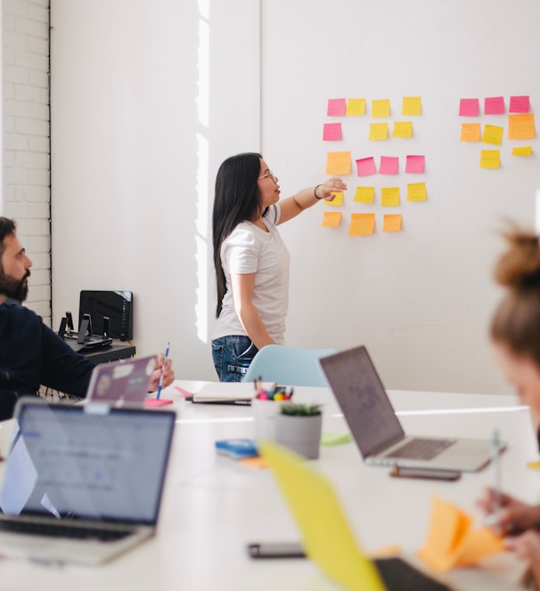 woman placing sticky notes on wall