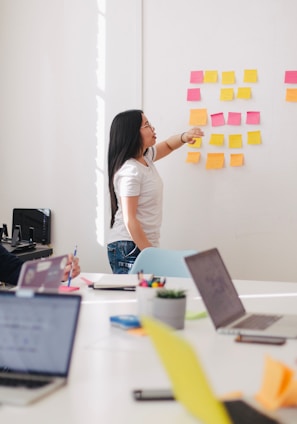 woman placing sticky notes on wall