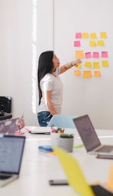 woman placing sticky notes on wall