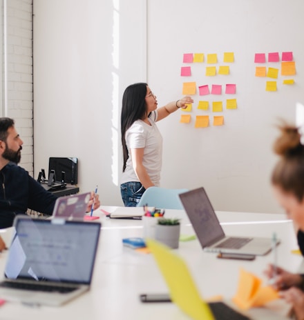 woman placing sticky notes on wall