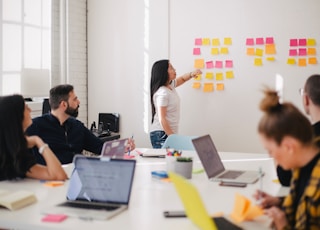 woman placing sticky notes on wall