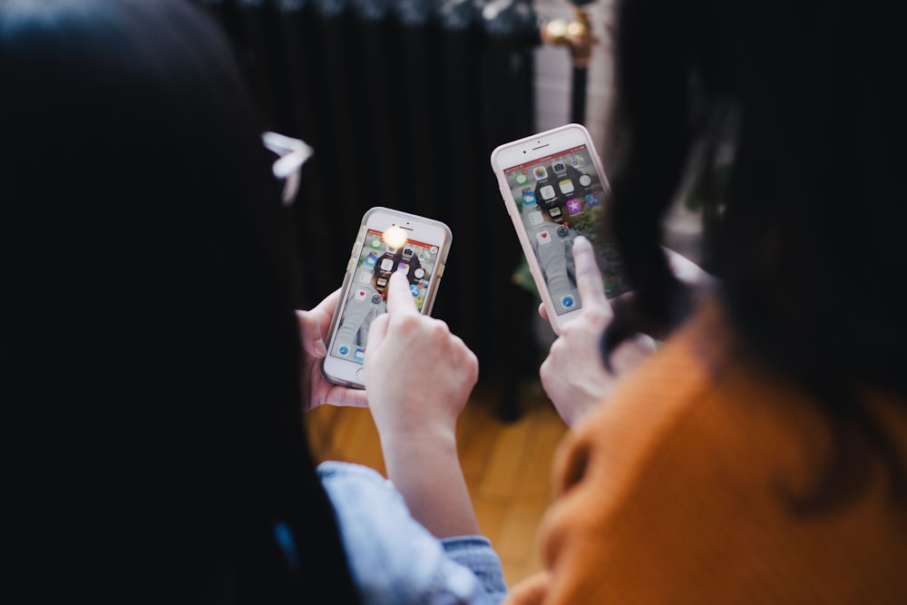 two women operating smartphone