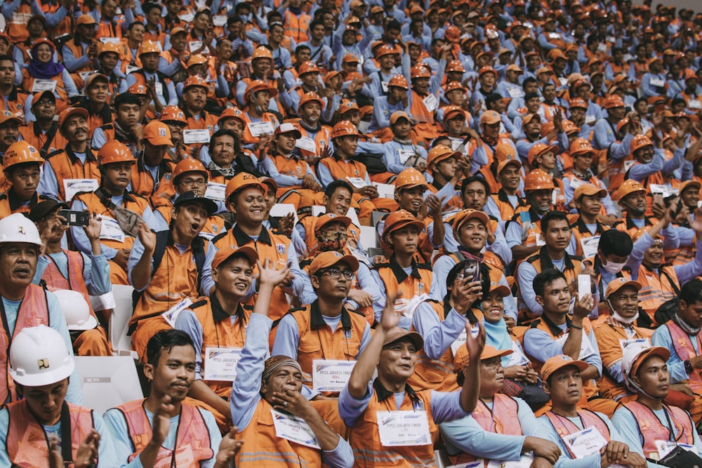 group of people wearing orange caps