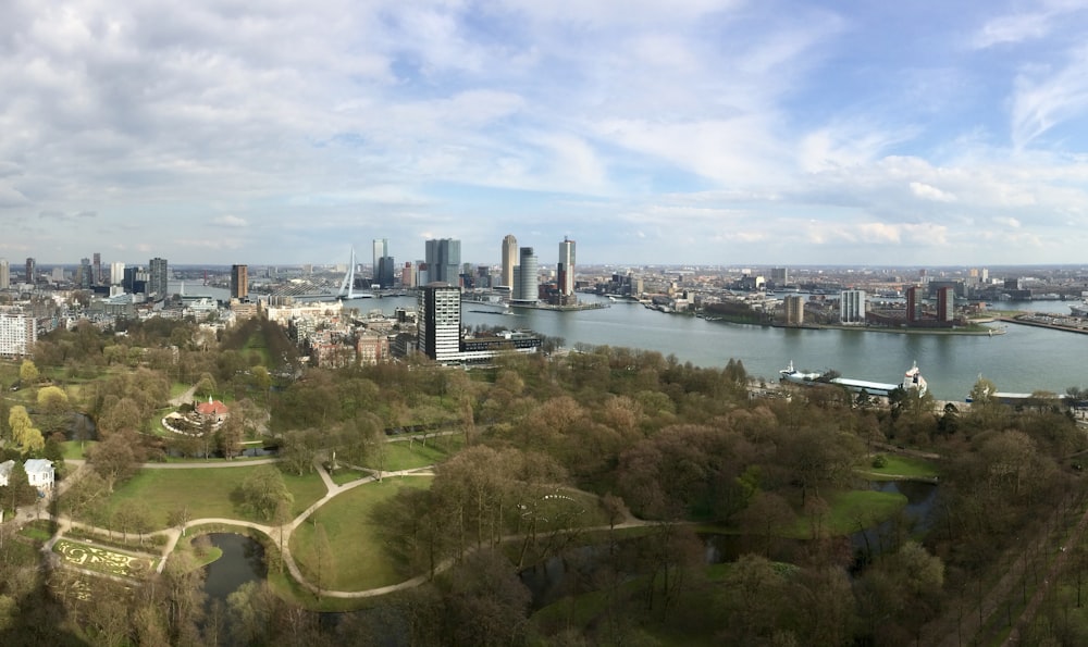 buildings and trees near river under cloudy sky at daytime