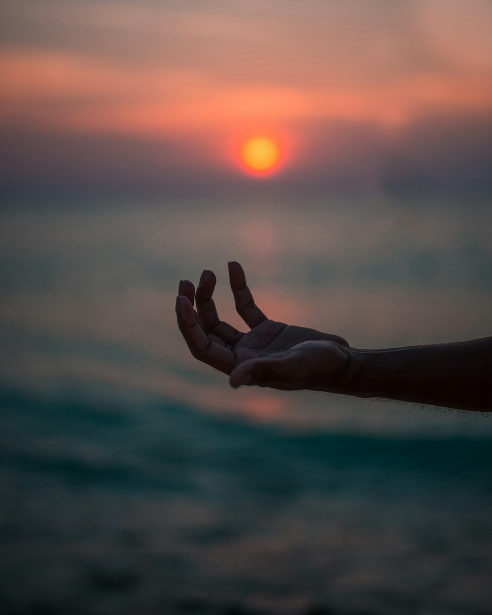 human hand near body of water