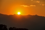 Sunset casting warm golden tones over the rugged Atlas Mountains from a valley viewpoint.