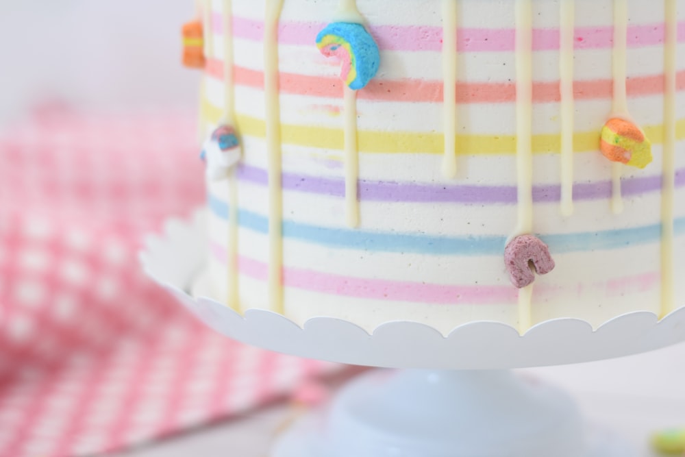 a multicolored cake on a white cake plate