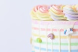 A pastel-colored cake with delicate sugar decorations and a smooth finish.