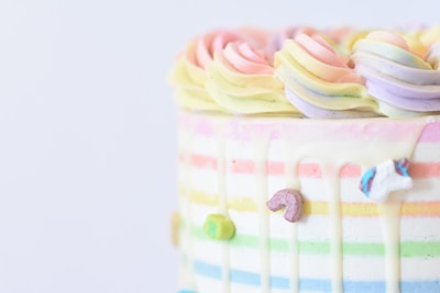 A pastel-colored cake with delicate sugar decorations and a smooth finish.