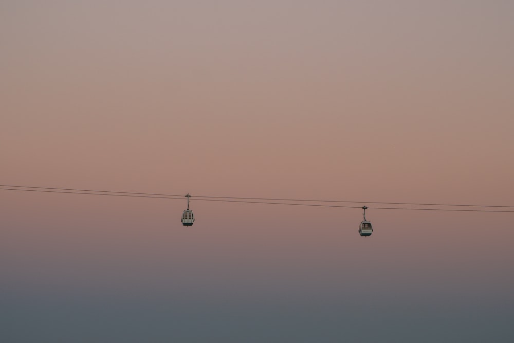 two cable cars traveling during sunset
