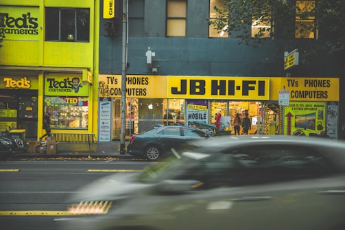 Exterior shot of a busy commercial district with various storefronts.